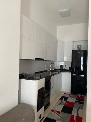 a kitchen with white cabinets and a black refrigerator at Unas apartment in Bihać
