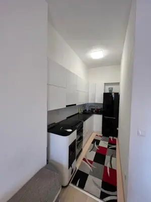 a kitchen with white cabinets and a black appliances at Unas apartment in Bihać
