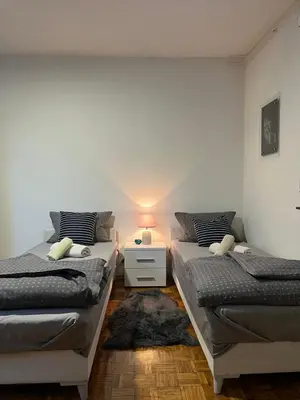 two twin beds in a room with a lamp at Apartman Centar Travnik in Travnik