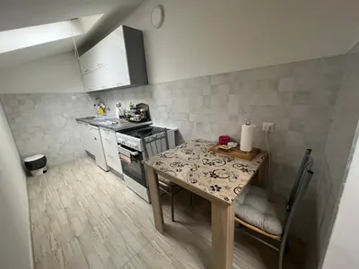 a small kitchen with a table and a stove at Apartman Centar Travnik in Travnik