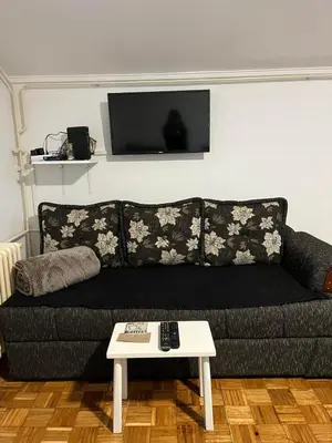 a black couch with a table in a living room at Apartman Centar Travnik in Travnik
