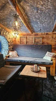 a room with a couch and a table and a chandelier at Zemljane kućice Kreševo in Kreševo