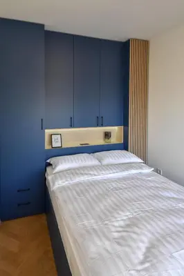 a bedroom with a large bed with blue walls at Apartman Filip in Banja Luka