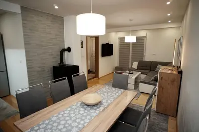a living room with a table and a couch at Planinska kuca NATURA in Vlasic