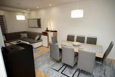 a living room with a table and chairs and a couch at Planinska kuca NATURA in Vlasic