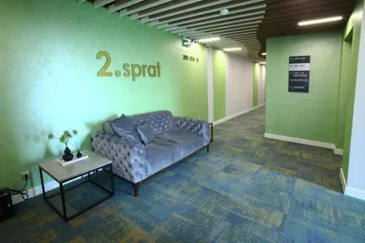 a couch in a room with a sign on the wall at Hotel ETNA in Gračanica