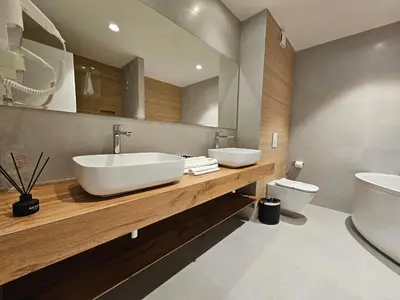 a bathroom with two sinks and a toilet at Hotel ETNA in Gračanica