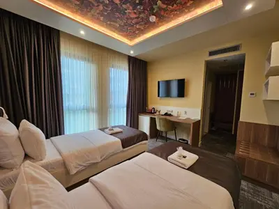 a hotel room with two beds and a tv at Hotel ETNA in Gračanica
