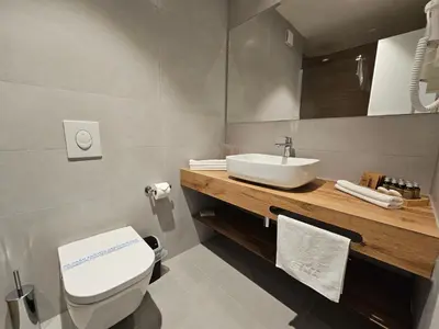 a bathroom with a white toilet and a sink at Hotel ETNA in Gračanica