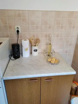 a kitchen counter with a counter top with food and a bottle of wine at Apartman Leko in Kupres
