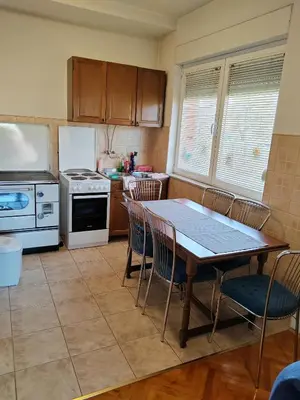 a kitchen with a table and chairs and a refrigerator at Apartman Leko in Kupres