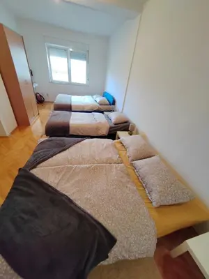 four beds lined up in a room at Apartman Leko in Kupres
