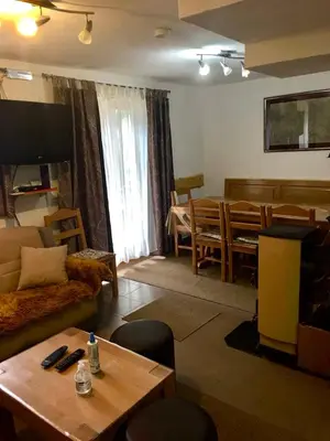 a living room with a couch and a dining room at Vikendica RAJ in Travnik