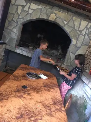 two children making pizzas in a brick oven at Vikendica RAJ in Travnik