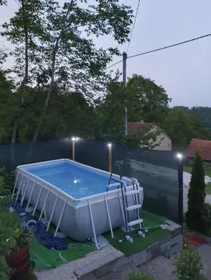 a hot tub in a yard with a chair next to it at Vikendica Cokori in Banja Luka