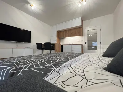a bedroom with a large bed with a tv on the wall at 7th Sky in Doboj