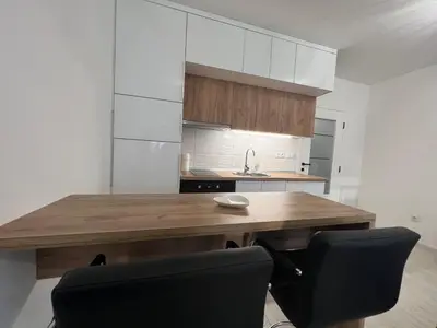a kitchen with a wooden table and a black chair at 7th Sky in Doboj