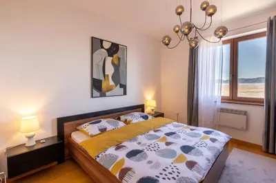 a bedroom with a bed and a large window at Madonna Sky in Kupres