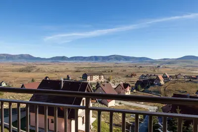 a view from a balcony of a town with mountains in the background at Madonna Sky in Kupres