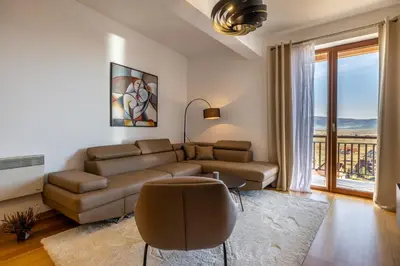 a living room with a couch and a large window at Madonna Sky in Kupres