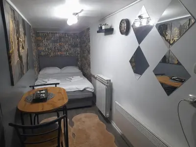 a small room with a bed and a table at APARTMAN POZORISTE Penthaus in Banja Luka