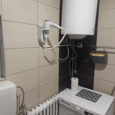 a bathroom with a toilet and a light on the wall at APARTMAN POZORISTE Penthaus in Banja Luka