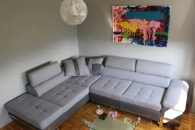 a living room with a couch and a painting at Comfortable apartment near the City Center in Banja Luka