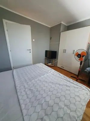 a bedroom with a white bed and two white doors at Comfortable apartment near the City Center in Banja Luka