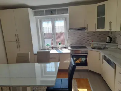 a kitchen with white cabinets and a stove top oven at Apartman Zoran in Livno