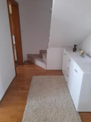 a room with a staircase and a dresser and a rug at Apartman Zoran in Livno