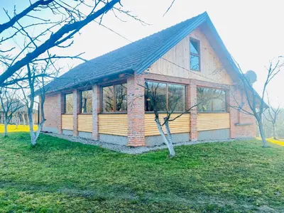 a small house with windows on a grass field at Vikend na Ozrenu in Bosansko Petrovo Selo