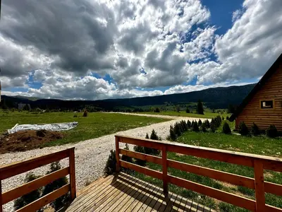 a wooden bench sitting on a path next to a house at Vlasic Odmor - Microcastl in Vlasic