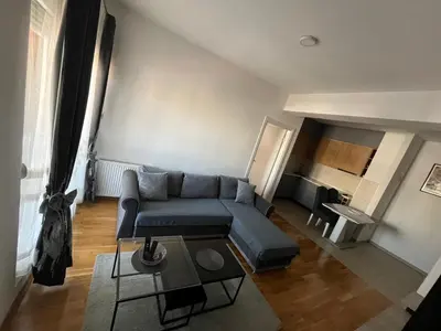 a living room with a blue couch and a table at APARTMAN MASA in Banja Luka