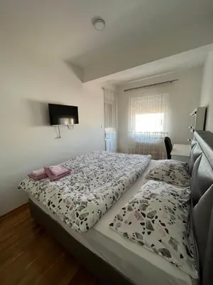 a bedroom with a bed with a comforter on it at APARTMAN MASA in Banja Luka
