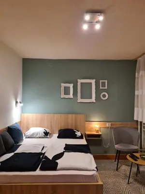 a bedroom with a large bed with a blue wall at Kineski zid in Zenica