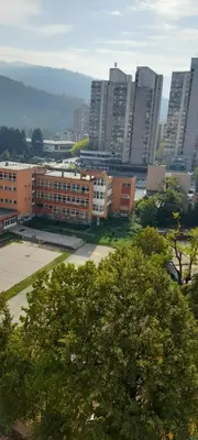 a view of a city with tall buildings and trees at Kineski zid in Zenica