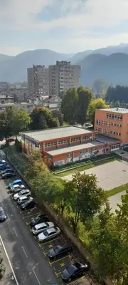 a parking lot with cars parked in front of a building at Kineski zid in Zenica