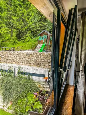a view of a garden from a sliding glass door at Vila Bašić Vlašić Apartman VUK in Vlasic