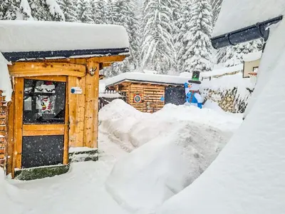 a building covered in snow next to a pile of snow at Vila Bašić Vlašić Apartman VUK in Vlasic