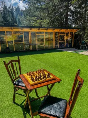 a chess board on a table and a chair at Vila Bašić Vlašić Apartman MEDO in Vlasic