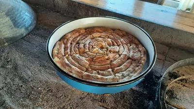 a large pie in a pan on a table at Apartman LELI in Kupres