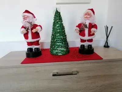 two santa claus figurines on a shelf next to a christmas tree at Apartman LELI in Kupres