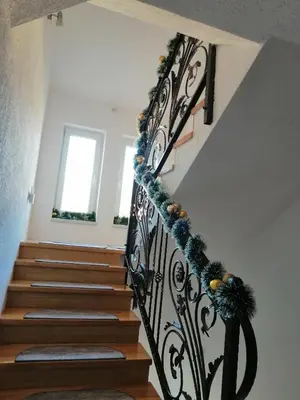 a staircase with a black wrought iron railing at Apartman LELI in Kupres