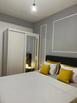 a bedroom with a large white bed with yellow pillows at Apartman Divine in Banja Luka