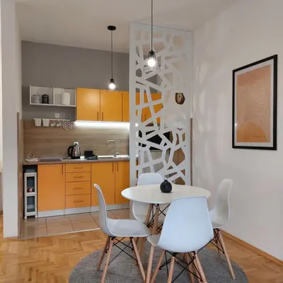 a kitchen with a table and chairs in a room at Apartman Divine in Banja Luka