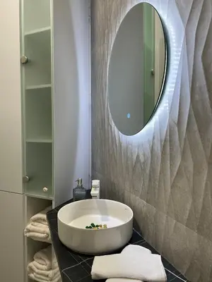 a bathroom with a large white tub and a mirror at Apartman Divine in Banja Luka