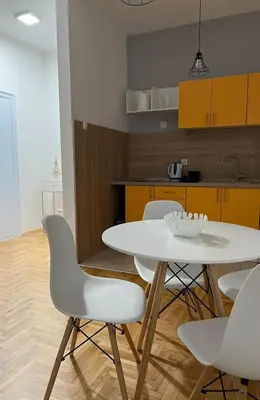 a kitchen with a white table and white chairs at Apartman Divine in Banja Luka