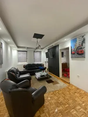 a living room with black leather chairs and a couch at Checkmate in Tešanj