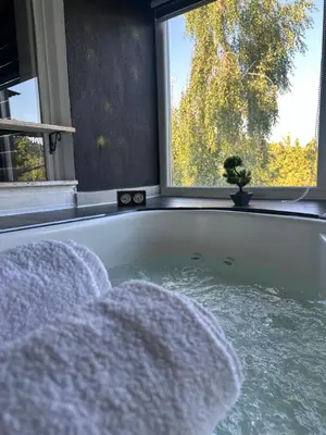 a bath tub with a view of a window at Checkmate in Tešanj