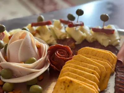 a plate of food with crackers and vegetables on it at Checkmate in Tešanj